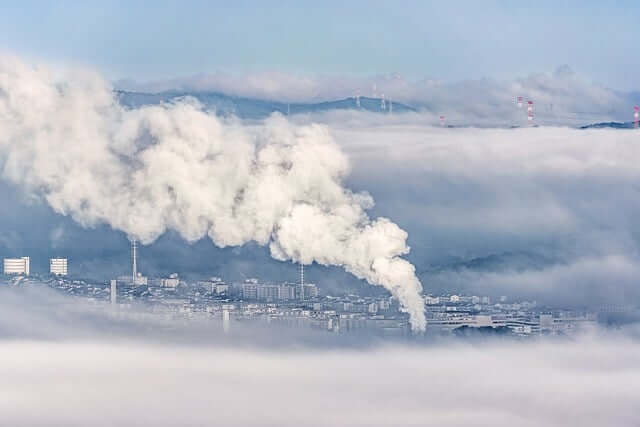 Fumo vindo da chaminé de uma fábrica poluindo os céus